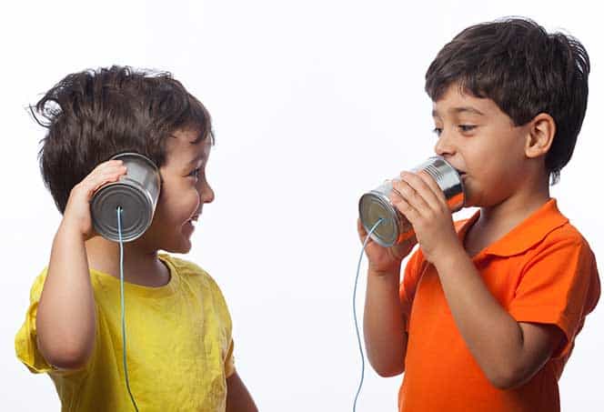Two children enjoying music with headphones, promoting communication and listening skills.