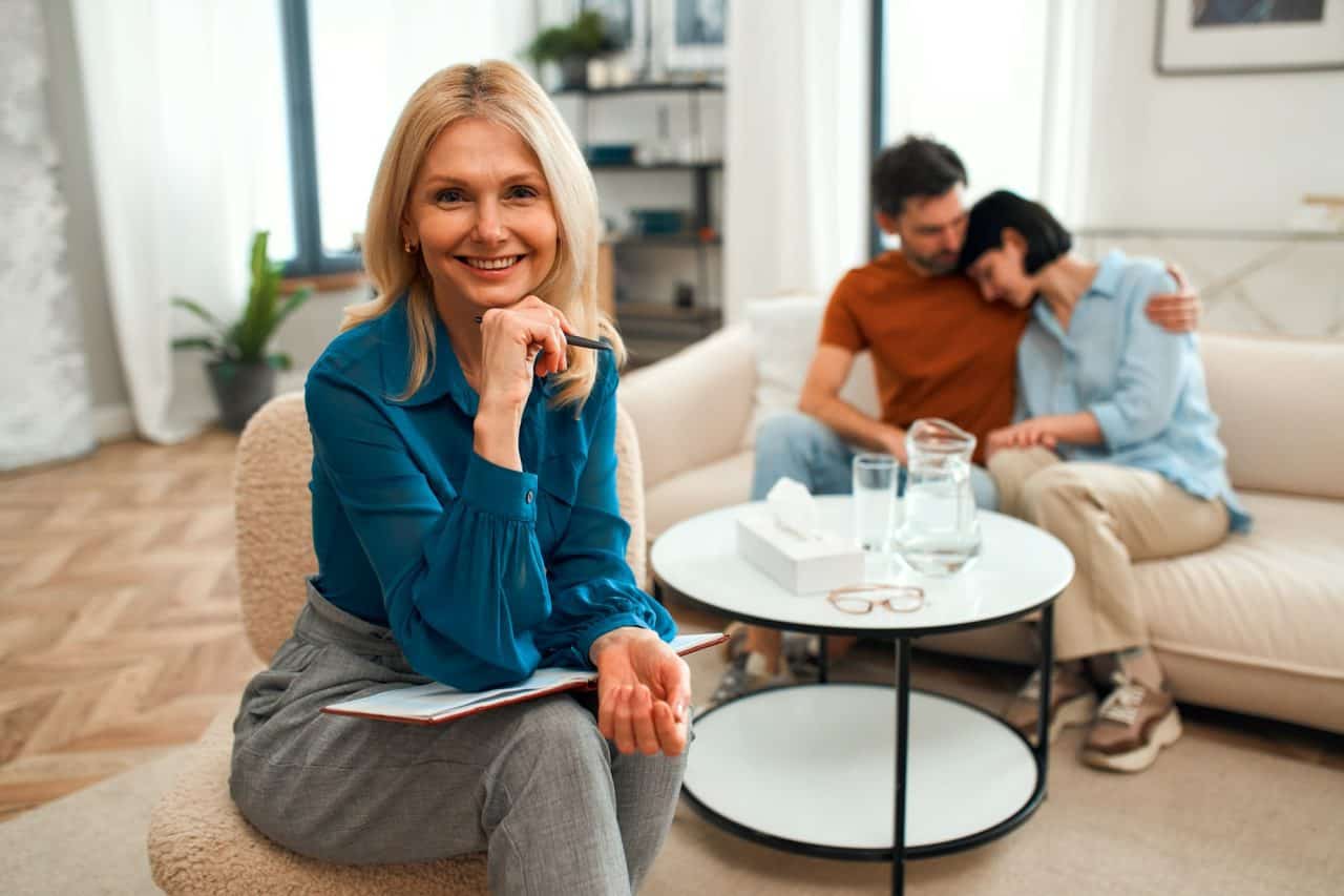 Effective communication therapy session with a smiling counselor and a couple in a cozy, modern livi.