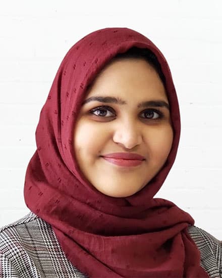 Woman wearing a maroon hijab smiling, promoting communication skills coaching for women.