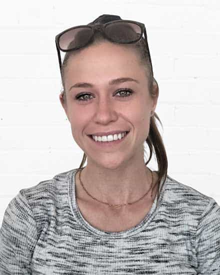 Woman smiling, wearing glasses on head, promoting communication skills coaching for women.