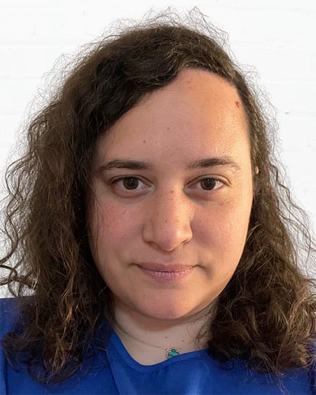 Woman with curly hair smiling, promoting communication skills coaching services.