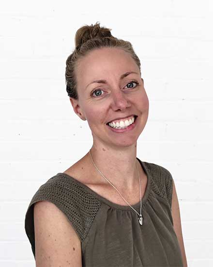 Friendly woman smiling, representing communication and customer service expertise.