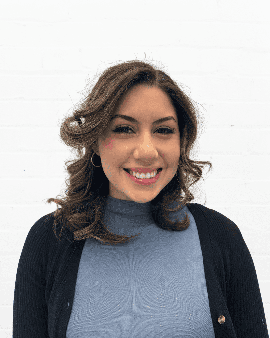Clear communication skills and friendly demeanor of a woman smiling in a professional setting.