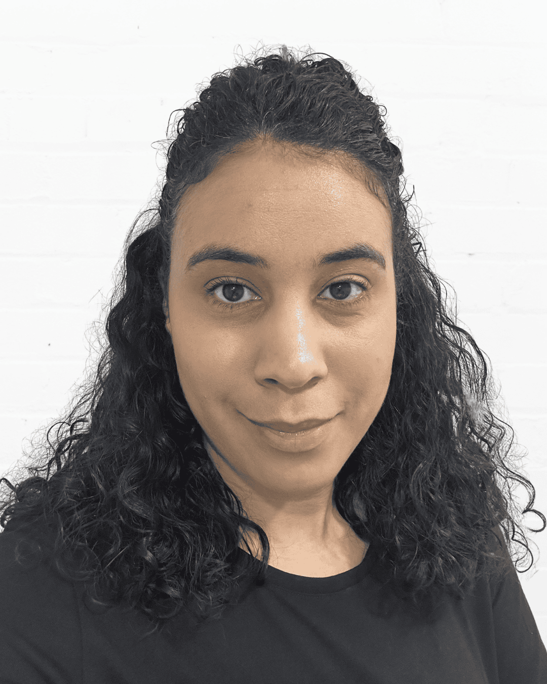 Woman with curly hair smiling, promoting communication skills and confidence.